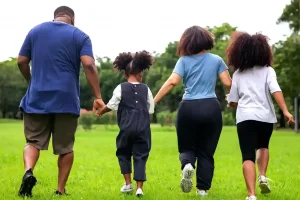 family holding hands walking in the park
